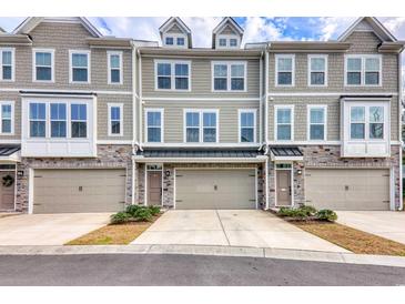 Charming townhouse exterior with stone accents, individual garages, and welcoming entrances at 2557 7B Pete Dye Dr. # 704, North Myrtle Beach, SC 29582