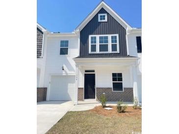 Modern two-story townhouse with white siding, black accents, garage, and well-maintained landscaping at 794 Nw Palm Frond Way # 48, Calabash, NC 28467