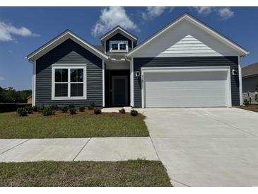 Charming home featuring navy blue siding, white trim, and a spacious two-car garage at 8640 Farrier Dr., Myrtle Beach, SC 29588