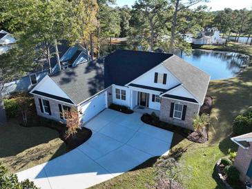 Stunning aerial view of home featuring a long drive, dark roof, neutral trim and a pond in the rear at 2588 Lake Vista Dr., Little River, SC 29566