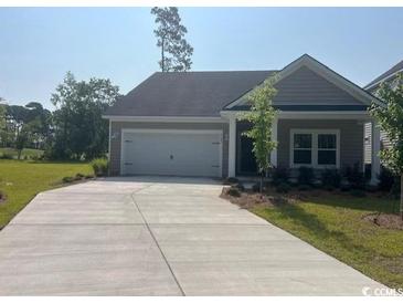 Charming single-story home featuring a wide driveway and attached two-car garage at 9742 Indigo Creek Blvd., Murrells Inlet, SC 29576