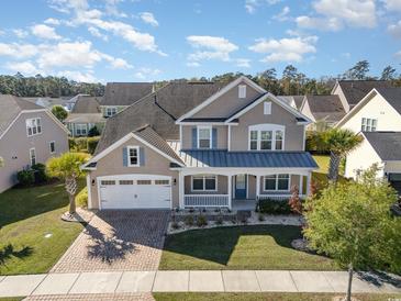 Charming two-story home featuring a covered porch, brick driveway, manicured lawn and two-car garage at 1549 Kensington Ln., Myrtle Beach, SC 29577