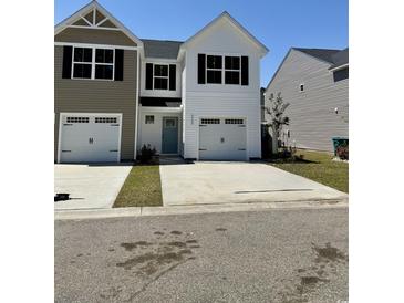 Charming, two-story townhouse with white siding, a blue door, and an attached single-car garage at 258-A Christiana Ln. # A, Myrtle Beach, SC 29579