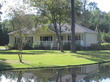 Charming home with a porch overlooking a serene pond and lush lawn at 1237 Spring Garden Rd., Conway, SC 29526