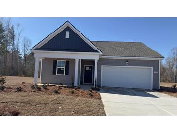 Charming single-story home featuring a covered front porch and attached two-car garage in a well-maintained community at 7287 Meadow Walk Loop, Loris, SC 29569
