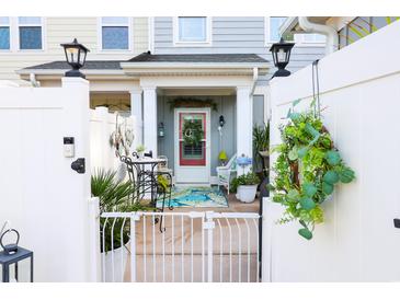 Inviting front porch with red door, bistro table, and decorative wreaths and potted plants at 2256 Heritage Loop # 2256, Myrtle Beach, SC 29577