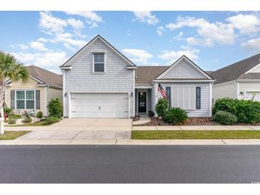 Two-story house with gray siding, white garage door, and landscaping at 404 Lorenzo Dr., North Myrtle Beach, SC 29582