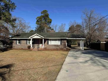 Brick ranch home with carport and landscaped yard at 209 Lewis St., Mullins, SC 29574