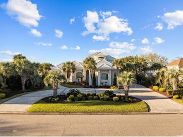 Stately home with lush landscaping, circular drive, and white tile roof at 3788 Waterford Dr., Myrtle Beach, SC 29577