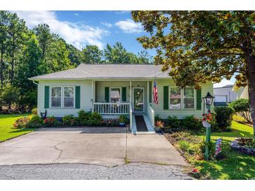 Charming single-story home featuring a cozy porch, green shutters, and well-manicured landscaping at 1305 Conifer Ct., Murrells Inlet, SC 29576