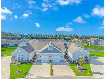 Charming townhomes with attached garages, manicured lawns, and beautiful landscaping near a pond at 830 San Marco Ct. # C, Myrtle Beach, SC 29579
