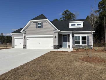 Charming home exterior featuring gray siding, stone accents, a two-car garage, and well-manicured lawn under a clear blue sky at 240 Palmetto Sand Loop, Conway, SC 29527