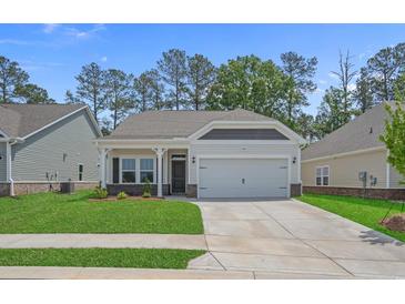 Charming single-story home with a well-manicured lawn and attached two-car garage on a sunny day at 2441 Campton Loop, Conway, SC 29527