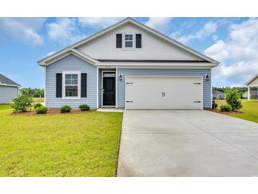 Charming exterior of a light blue home featuring a two-car garage, black shutters, and manicured landscaping at 1044 Jase Dr., Longs, SC 29568
