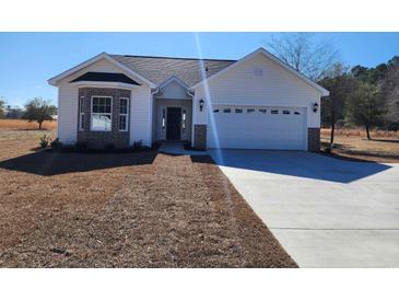 Charming single-story home featuring a classic design, attached garage, and well-manicured front lawn at 2770 Daisy Rd., Loris, SC 29569