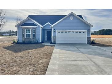 Charming single-story home with blue siding, a two-car garage, and a well-manicured lawn at 2814 Daisy Rd., Loris, SC 29569