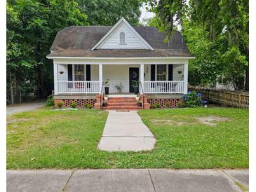 Charming white one-story home with front porch, landscaped yard, and inviting curb appeal at 306 E Godbold St., Marion, SC 29571