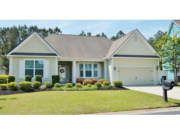 Charming single-story home with well-manicured lawn and colorful flowerbeds leading to an attached two-car garage at 64 Summerlight Dr., Murrells Inlet, SC 29576