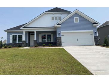 Charming single-Gathering home featuring stone accents, a two-car garage, and a well-manicured lawn at 993 Oak Hollow St., Longs, SC 29568