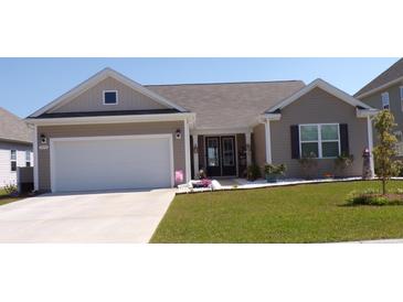 Charming single-Gathering home with a well-manicured lawn, a two-car garage, and tasteful landscaping at 3070 Sutherland Dr., Little River, SC 29566