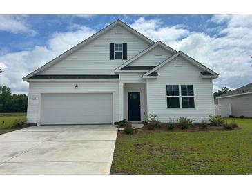 Charming new construction home featuring white siding, a two-car garage, and a well-maintained front lawn at 328 Glade Ct., Loris, SC 29569