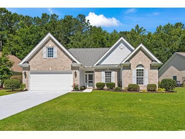 Charming brick home with a well-manicured lawn, attached garage, and inviting front entrance at 765 Ashley Manor Dr., Longs, SC 29568