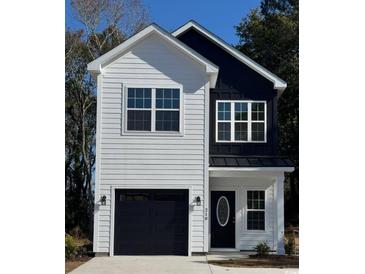 Charming two-story home with modern design, featuring black and white exterior and a well-manicured lawn at 210 26Th Ave. S, Myrtle Beach, SC 29577