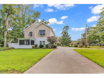 Inviting two-story home featuring a screened-in porch and long driveway at 613 Lee Ave., Murrells Inlet, SC 29576