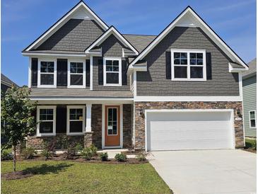 Charming two-story home featuring stone accents, gray siding, a two-car garage, and a well-manicured lawn at 562 Haven View Way, Murrells Inlet, SC 29576