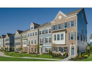Beautiful street view of colorful brick and siding townhomes with manicured lawns on a sunny day at 8476 Duke Pl. # 32, Myrtle Beach, SC 29572