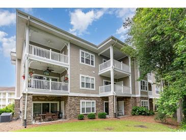 Multi-story condo featuring multiple balconies, stone accents, and outdoor seating area at 109 S Shore Blvd. # 104, Longs, SC 29568