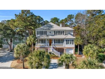 Two-story home with gray metal roof, brick accents, and a landscaped yard at 112 Cockle Shell Ct., Pawleys Island, SC 29585