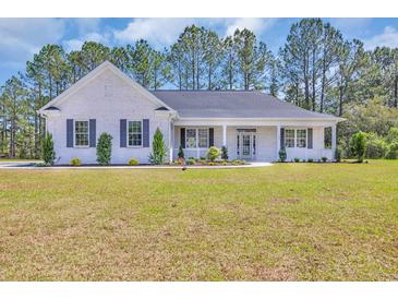 Charming white brick home with inviting front porch and well-manicured landscaping at 1151 Bear Lake Dr., Longs, SC 29568