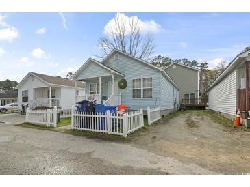 Charming light blue home with a white picket fence and front porch, offering curb appeal at 815 Rogers Dr., Myrtle Beach, SC 29577