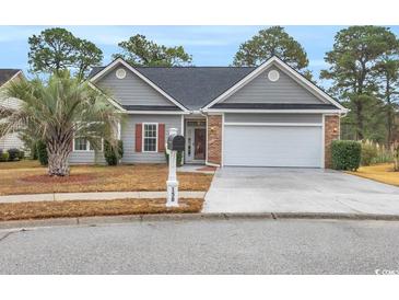 Charming home featuring a two car garage, well-maintained landscaping, and a beautiful palm tree in the front yard at 158 Regency Dr., Conway, SC 29526