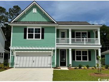 Charming two-story home features a welcoming front porch, light green siding, and attached two car garage at 535 Slaty Dr., Myrtle Beach, SC 29588