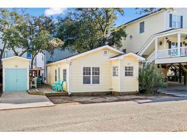 Charming yellow cottage with deck, storage shed, and colorful patio furniture at 6001 - D07 S Kings Hwy., Myrtle Beach, SC 29575