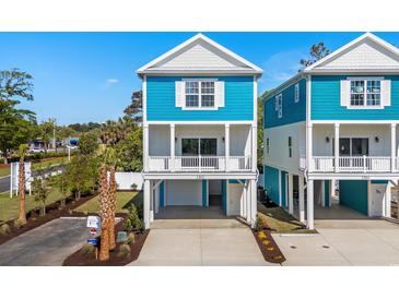 Charming two-story coastal home with a blue exterior, white trim, and a convenient drive-under garage at 2302 Seaseeker Ln., Myrtle Beach, SC 29577