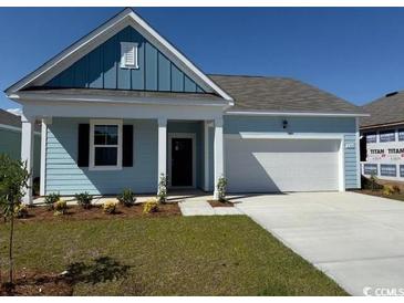 Charming one-story home showcasing light blue siding, a neatly manicured lawn, and a two-car garage at 544 Duvall St., Longs, SC 29568