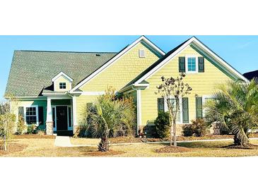 Charming home with a green exterior, well-manicured lawn, and beautiful landscaping at 8605 Hopper Ct., Myrtle Beach, SC 29579