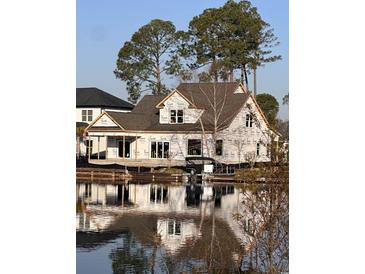 Waterfront home with large windows reflected in the water offers scenic views at 1020 Clamour Ct., Conway, SC 29526