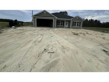 Newly constructed home with a gray exterior, attached garage, and landscaping at Tbd 8 Casey Dr., Nichols, SC 29581