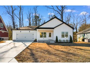 White farmhouse-style home with gray accents and a two-car garage at 306 Rivers Edge Dr., Conway, SC 29526