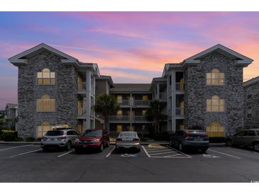 Two-story building exterior with brick facade and parking lot at 4753 Wild Iris Dr. # 104, Myrtle Beach, SC 29577