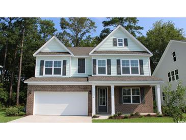 Two-story home with brick and siding, a white door, and a landscaped lawn at 807 Ireland Dr., Longs, SC 29568