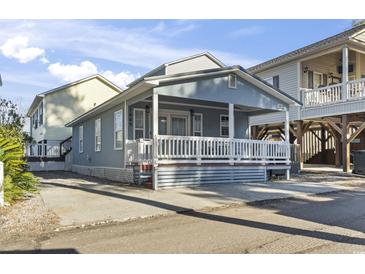 Charming single-story beach house with a spacious covered porch and beachy blue siding at 6001 South Kings Hwy., Myrtle Beach, SC 29575