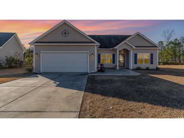 Beige house with a two-car garage and a nicely landscaped lawn at 817 Payne Ct., Conway, SC 29526