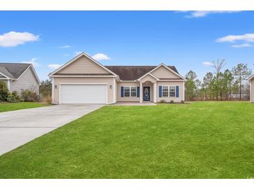 Charming single-story home featuring a well-manicured lawn, attached garage, and blue shutters against a bright blue sky at 817 Payne Ct., Conway, SC 29526
