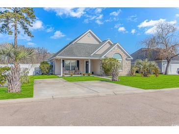 Brick and shingle front elevation of charming house with manicured lawn and driveway at 204 Atoll Dr., Myrtle Beach, SC 29588