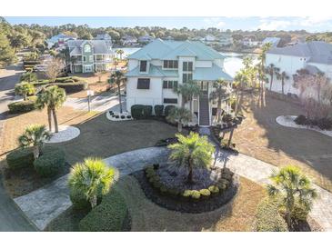 Luxury waterfront home with circular driveway and lush landscaping at 47 Isle Of Palms Dr., Murrells Inlet, SC 29576